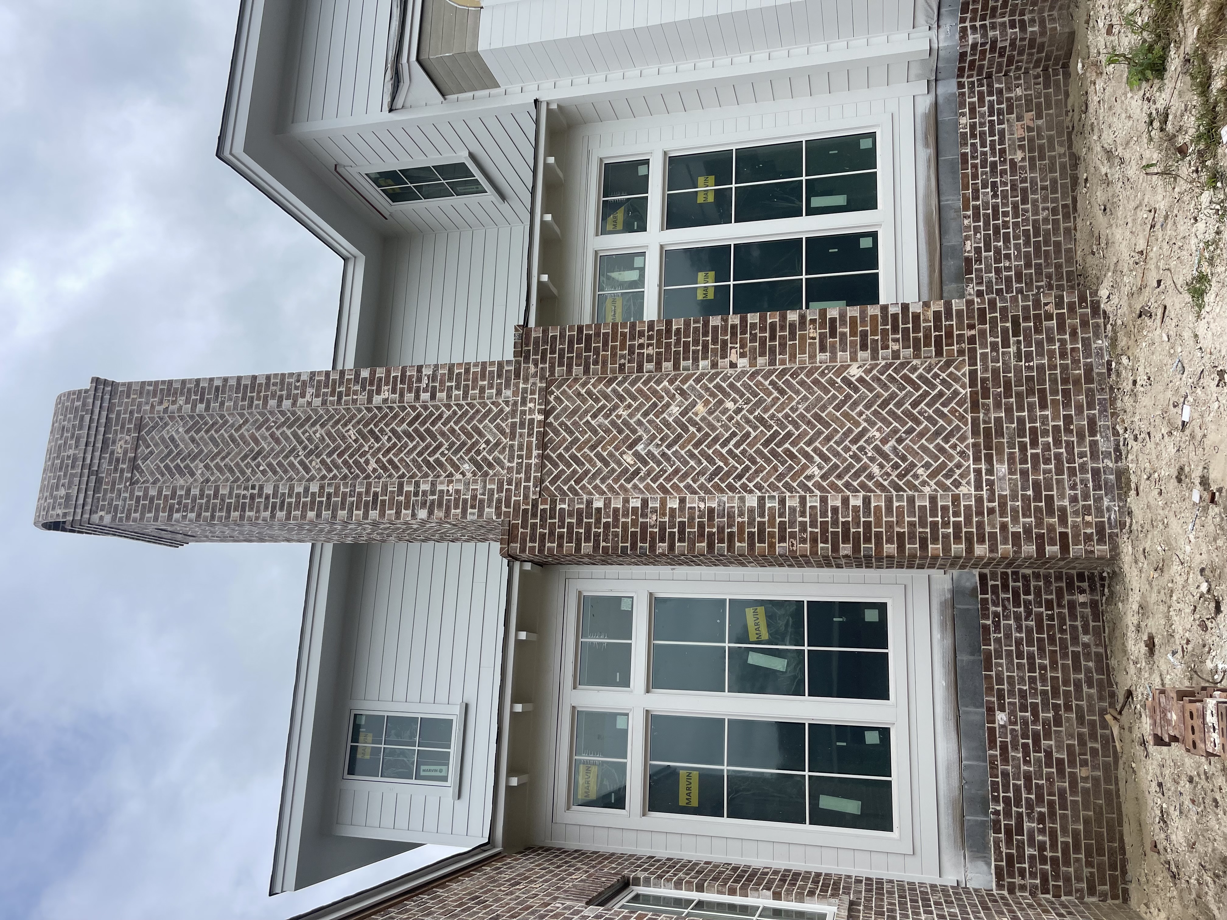 Herringbone brick facade with board-and-batten siding on custom home