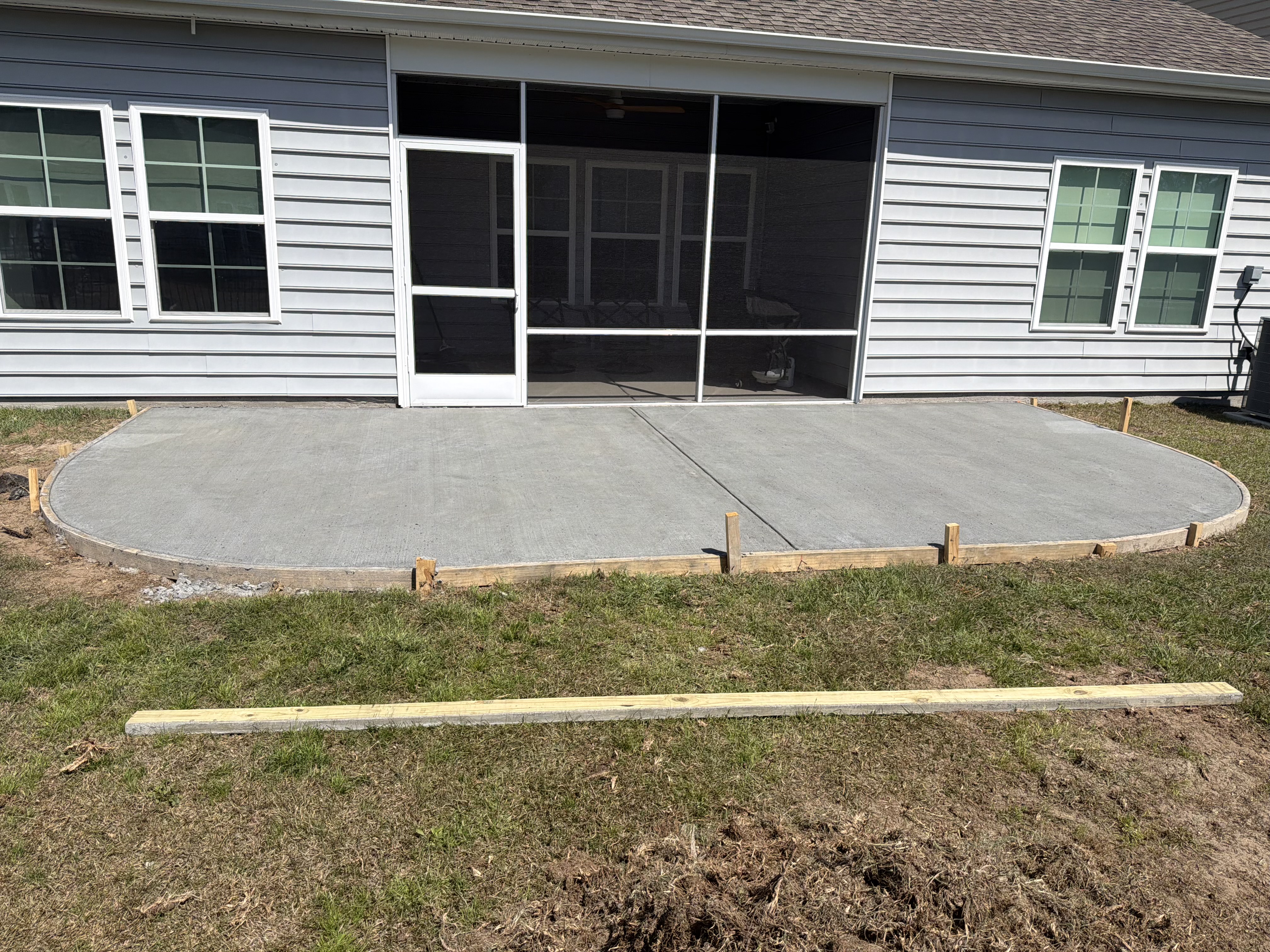 Freshly poured concrete patio behind residential home